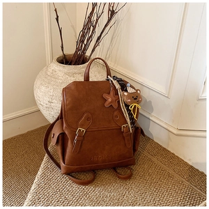 Detail of dark brown vintage faux leather backpack with buckle closure and logo