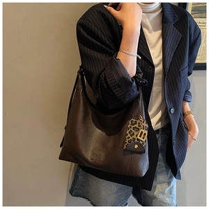 Detail der braunen Shopper-Tasche mit Leopardenmuster-Anhänger und goldenem B-Logo