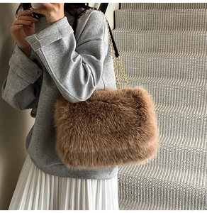 Detailed view of brown faux fur shoulder bag with golden metal chain strap on model