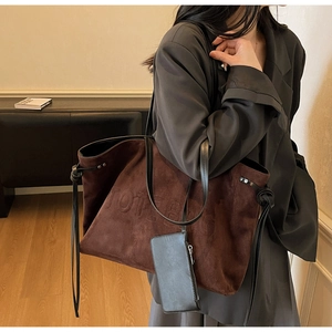 Dettaglio della grande borsa tote in pelle scamosciata marrone scuro con goffratura