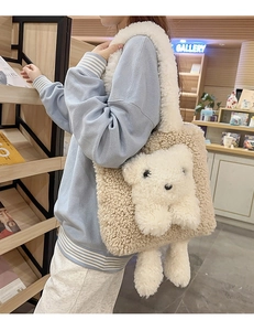 Dettaglio della borsa tote in pile beige con orsetto 3D indossata da una modella