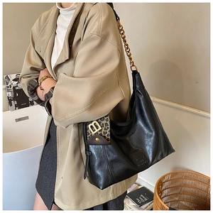 Detail einer schwarzen Leder-Tote mit Leoparden-Klappe und goldener B-Logo-Schnalle