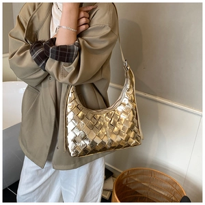 Nahaufnahme der goldenen geflochtenen Hobo-Tasche mit Fokus auf die Webstruktur
