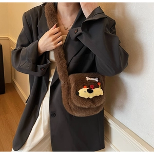 Détail d'un sac à main marron en fausse fourrure avec un chien 3D et un décor d'os