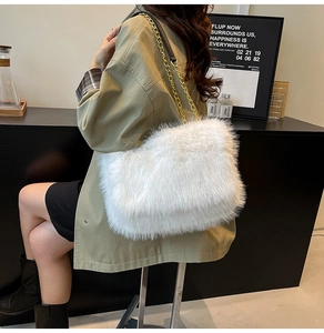 Close-up of fluffy white faux fur shoulder bag featuring elegant gold metal chain strap