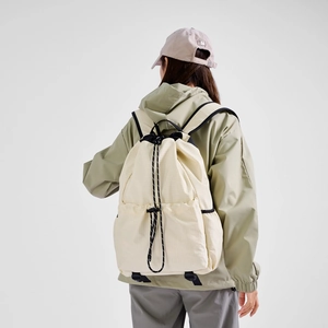 Detailed back view of a beige drawstring backpack with black ropes and ripstop texture