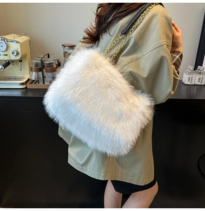 Detail of white faux fur shoulder bag with gold chain strap in an elegant cafe setting