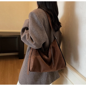 Detail of dark brown suede tote bag featuring a soft texture and spacious commuter style