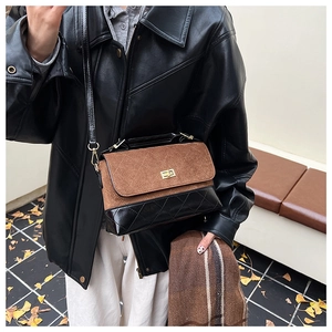 Détail du sac bandoulière vintage avec daim marron, cuir matelassé noir et fermoir doré