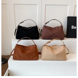 Detail view of suede Boston bags in four colors with gold zippers and adjustable straps