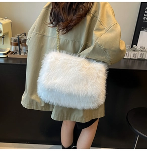 Detail of soft white faux fur tote bag with long fluffy texture and elegant gold chain strap