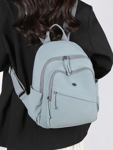 Light blue lightweight nylon backpack featuring multiple zipper pockets and sleek metal logo
