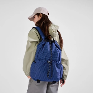 Detail of blue grid drawstring backpack with woven ropes and ergonomic shoulder straps