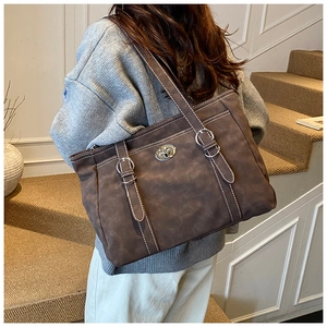 Détail du grand sac cabas marron foncé avec coutures contrastées et fermoir en métal