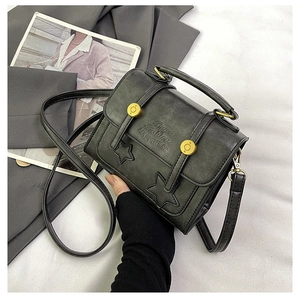 Close-up of black retro crossbody bag with star stitching and vintage gold buckles