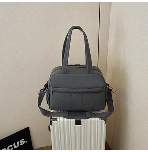 Close-up of charcoal gray travel bag with durable nylon and adjustable shoulder strap