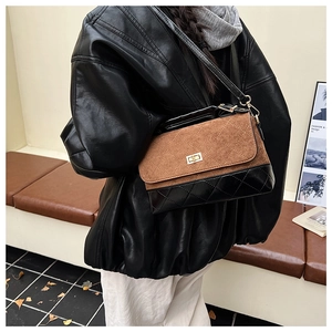 Détail du sac bandoulière matelassé rétro en tissu givré marron et cuir noir élégant