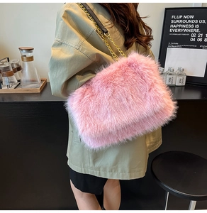 Detailed view of pink faux fur shoulder bag with golden metal chain strap on model