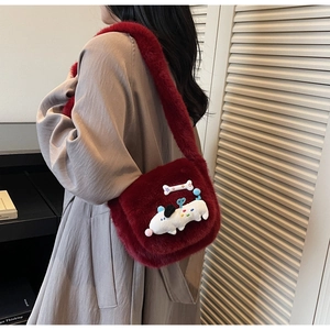 Détail du sac en peluche bordeaux avec motif chien porté sur un manteau gris
