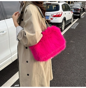 Detailed view of the bright pink faux fur texture and gold chain strap of the shoulder bag