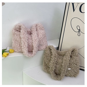 Detail of pink and khaki teddy faux fur handbags on a minimalist display with flowers