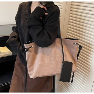 Dettaglio della borsa tote in pelle scamosciata marrone con goffratura TOTE BAG e pochette