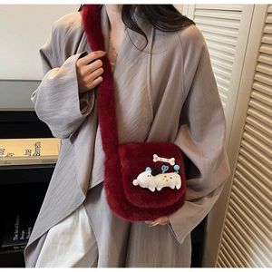 Détail du mini sac bordeaux en fausse fourrure avec peluche chien sur un manteau gris
