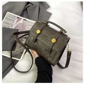 Close-up of retro brown crossbody bag with star patches and embossed fashion lettering