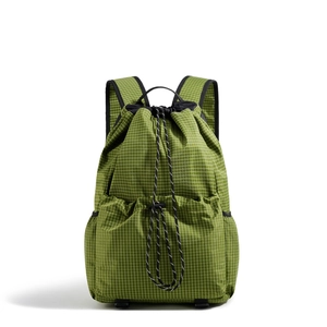 Detail of green ripstop fabric and adjustable drawstrings on outdoor backpack