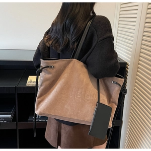 Dettaglio della borsa tote vintage in pelle scamosciata marrone con scritta a rilievo