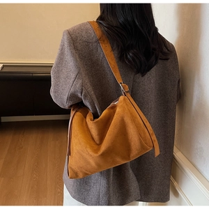 Back view of model wearing a large brown suede shoulder bag with vintage texture