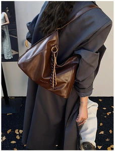 Détail d'un grand sac fourre-tout marron foncé avec nœuds tressés et anneaux en métal