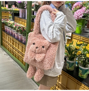 Close-up of pink plush teddy bear shoulder bag worn by model in a casual setting