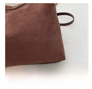 Close-up of brown matte suede texture with leather strap and metal zipper detail