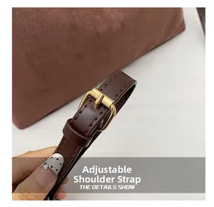 Macro detail of adjustable brown leather shoulder strap with gold-tone buckle hardware