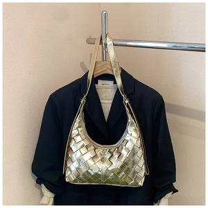 Nahaufnahme der goldenen geflochtenen Hobo-Bag mit Metalltextur und Karomuster-Gewebe