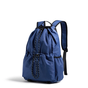 Close-up of blue micro-check drawstring backpack with padded straps and side mesh pockets