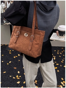 Détail du sac cabas vintage en daim marron avec surpiqûres et fermoir métallique