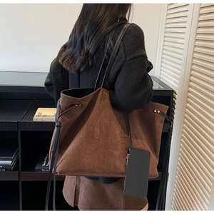 Dettaglio della borsa tote in pelle scamosciata caramello con scritte in rilievo