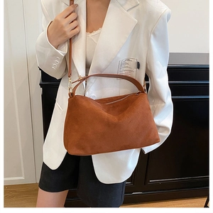 Chic brown matte suede tote bag styled with a white blazer and black shorts