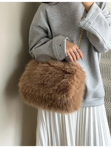 Brown faux fur tote bag with gold chain strap shown on a model in a casual outfit