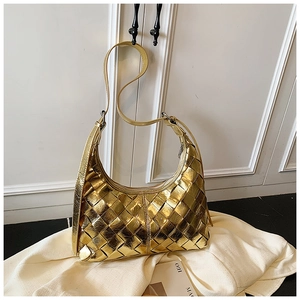 Detailansicht der goldfarbenen Web-Hobo-Tasche mit breiten Lederriemen auf weißem Stoff