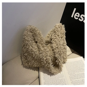 Close-up of beige faux lamb wool texture on a stylish autumn winter tote bag