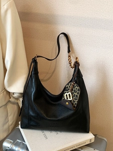 Klassische schwarze Hobo-Tasche aus Leder mit Goldkette und Anhänger im Leopardenmuster