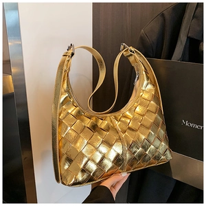 Detail der goldenen geflochtenen Hobo-Tasche mit Metalloptik und Schultergurt