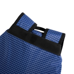 Detail of navy drawstring backpack showing waterproof grid fabric and nylon handle