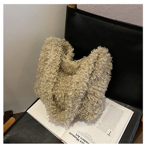 Detail of plush beige faux shearling tote bag resting on a minimalist leather chair