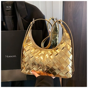 Detailaufnahme der goldenen geflochtenen Lederstruktur einer modernen Hobo-Tasche