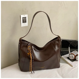 Détail du sac cabas en cuir marron café avec breloque étoile dorée et texte embossé
