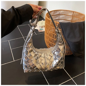 Detail der silbernen geflochtenen Hobo-Tasche mit geometrischer Textur und Schultergurt